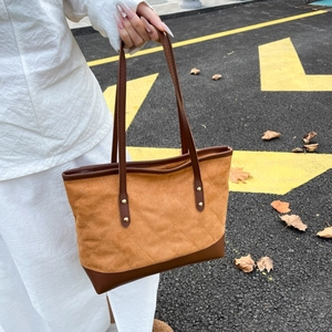 Détail du sac fourre-tout matelassé en daim avec lanières en cuir et rivets