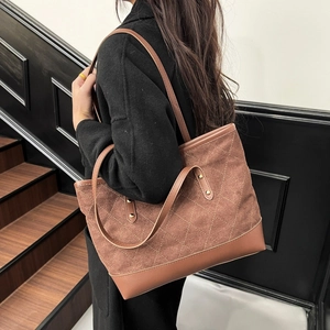 Detail view of brown suede tote bag with quilted diamond pattern for everyday use