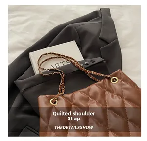 Detail of brown quilted shoulder bag featuring premium chain and leather strap design