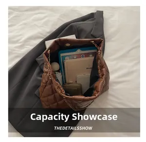 Spacious interior of brown quilted chain shoulder bag with daily essentials inside