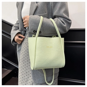 Detailaufnahme der hellgrünen Handtasche aus Leder mit Kieselprägung und Goldaufdruck