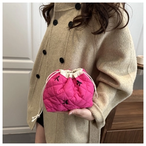 Detail of rose red quilted drawstring cosmetic bag with black bow embroidery