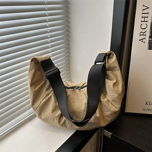 Khaki nylon crescent crossbody bag with pleated texture and adjustable strap