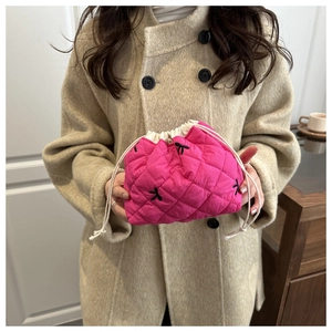 Quilted rose red drawstring cosmetic bag featuring black embroidered bows and cotton rope