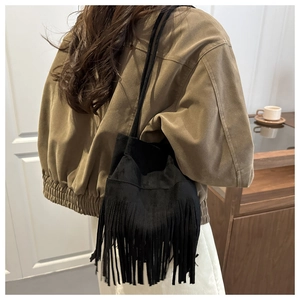 Vue arrière d'un mannequin portant un sac seau bohème noir avec de longues franges en daim