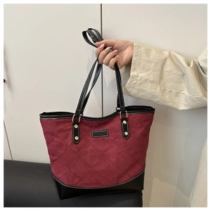 Detail der burgunderroten Stepptasche mit schwarzem Lederbesatz und modischem Tag