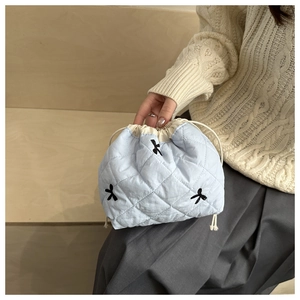 Pochette trapuntata azzurra con ricamo a fiocco nero e chiusura a coulisse
