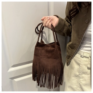 Détail du sac à franges en daim marron foncé avec texture bohème rétro vintage
