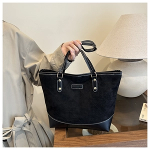 Detail of checkered tote bag with quilted stitching and polished FASHION metal plate