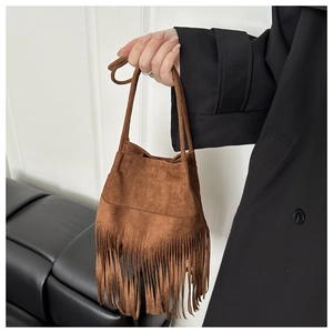 Détail du sac en daim marron avec de longues franges dans un style vintage boho