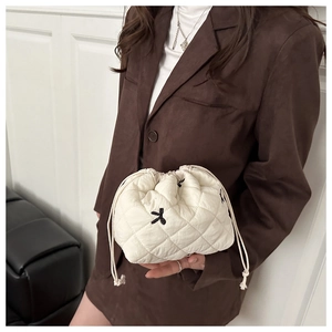 Close-up of quilted cream tote bag featuring rabbit embroidery and drawstring closure