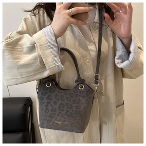 Macro shot of grey leopard print bucket bag in premium suede with gold buckle detail