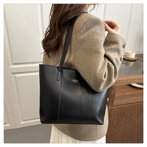 Sac fourre-tout noir en cuir grainé avec texte doré porté à l'épaule