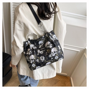 Detail of skull and floral print tote bag on a woman's shoulder