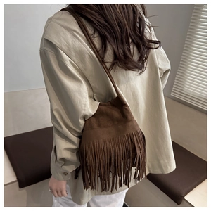 Vue détaillée d'un sac bandoulière marron à franges vintage porté par un mannequin