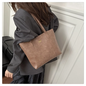 Sac cabas en cuir marron avec texte doré FASHION BAGS porté par un mannequin chic
