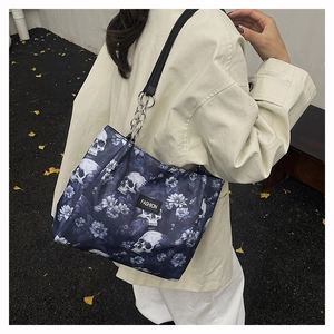 Detail of the unique skull and floral print pattern on a stylish black shoulder bag