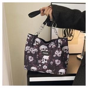 Close-up of gothic tote bag featuring white skull and purple floral patterns with metal chain