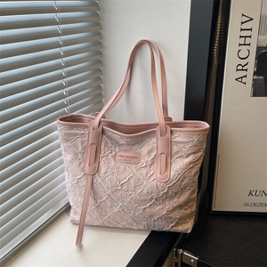 Pink quilted tote bag with white flower embroidery and long shoulder straps for women