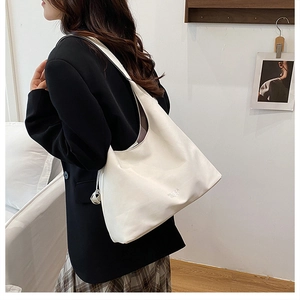 On-shoulder view of a large white PU leather hobo tote bag showing its capacity and fit
