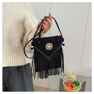 Close-up of black suede tassel bag with V-shaped golden studs and vintage crystal