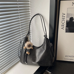 Retro large capacity dark grey tote bag with bear charm on a bright windowsill