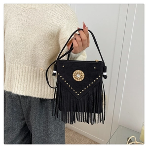 Close-up of black suede saddle bag with golden studs, tassel fringe and metal logo