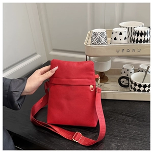 Close-up of red lychee pattern leather crossbody phone bag with gold zipper and fabric strap