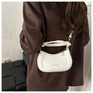 Detail of white half-moon hobo bag with unique knotted handle and gold metal hardware