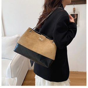 Detail of the chain strap and quilted paneling on the bicolor tote bag