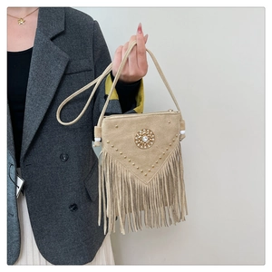 Close-up of bohemian suede square bag with rivet details and long flowing fringes