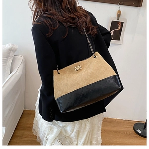 Detail view of khaki suede and black leather shoulder bag with gold twist lock