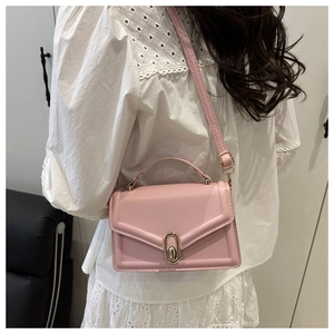 Detail of pink PU leather crossbody bag with elegant oval metal swivel lock and fine stitching
