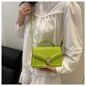 Detail of neon green PU leather handbag with gold oval lock and detachable strap
