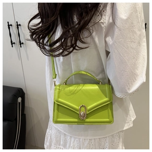 Lime green mini flap bag with gold oval twist lock shown on model with lace top