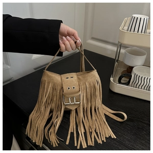 Détail d'un sac à bandoulière marron en daim avec de longues franges et boucle argent