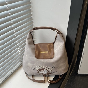 Grey canvas tote bag with brown leather accents and a retro baseball cartoon print