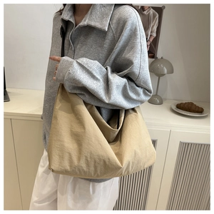 Detail of khaki waterproof nylon hobo bag with wide shoulder strap in minimalist setting