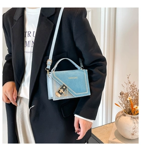 Detail of light blue suede crossbody bag with gold buckle and Fashion & Bags text