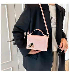 Detailed shot of pink crossbody bag with fashion gold chain lock and top handle