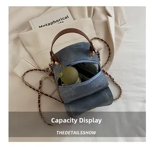 Capacity display of a denim cylinder bag showing storage space for phone and umbrella