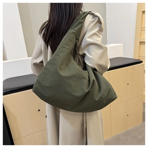 Olivgrüne Halbmond-Tragetasche aus Nylon am Model für einen entspannten Freizeitlook