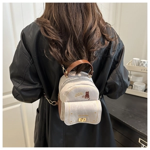 Detail view of mini backpack with cat illustration and metal buckle worn on the back