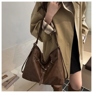 Detail of vintage brown oil wax leather shoulder bag with metal buckle and soft structure
