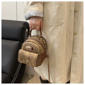 Detail of brown faux leather mini backpack with cat print and gold metal lock