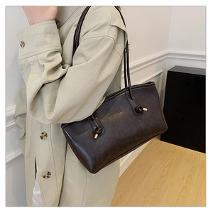 Detail of deep brown retro leather tote bag featuring elegant leather knots and metal hardware