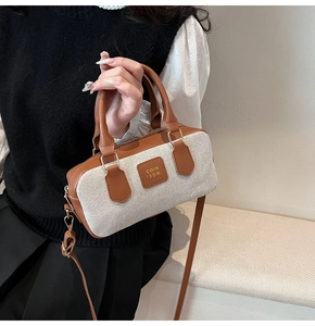 Detail of canvas and brown leather Boston bag with metallic zipper and handle
