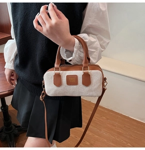 Detail of canvas and brown leather bowling bag with vintage top handles and metal hardware