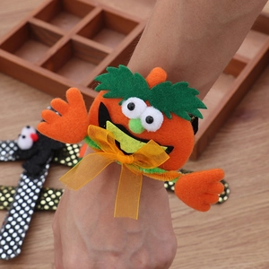 Detail of Halloween pumpkin snap bracelet with orange felt material and festive bow decoration