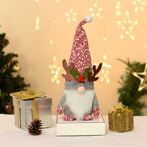 Weihnachtswichtel Plüschfigur mit Rentiergeweih und roter Strickmütze in Festtagsdekoration